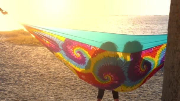 Vriendinnen Kijken Naar Zonsondergang Een Regenboog Kleuren Hangmat Tussen Palmbomen — Stockvideo