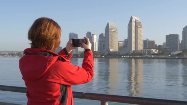 Женщина-путешественница использует телефон с панорамным видом на улицу фото . — стоковое видео