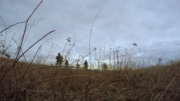 Helikopter vliegt over soldaten op slagveld — Stockvideo