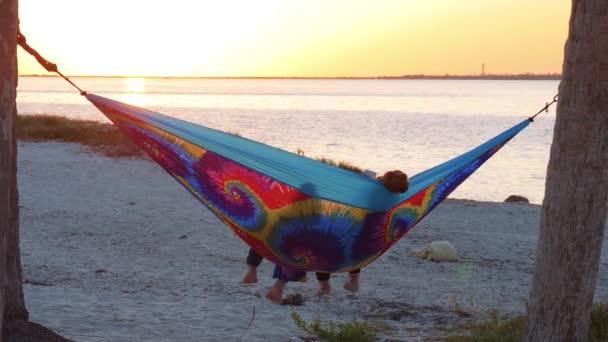 Girlfriends watching sunset in hammock. — Stock Video