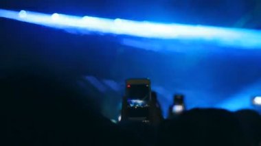 Seyirci telefonda sanatçı sahnede bir performans sırasında filme. Bir sürü insan smartphone ile kayda açık veya canlı konser sırasında fotoğraf çekmek.