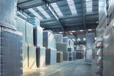 Geniş depo dolu cam şişe ile aydınlatılmış. Depodaki şişe cam Fabrika ambalaj. Dolu cam şişeler ile depo