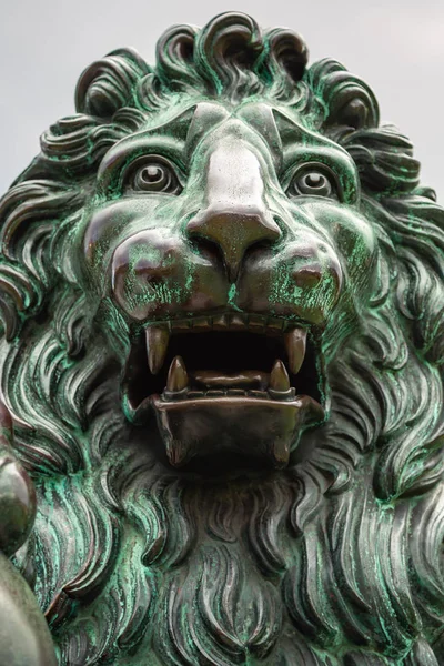 Close up of the head of a bronze sculpture of lion