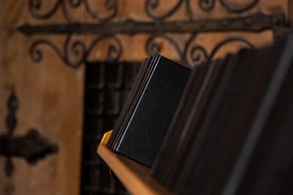 Black books on a shelf in an old castle
