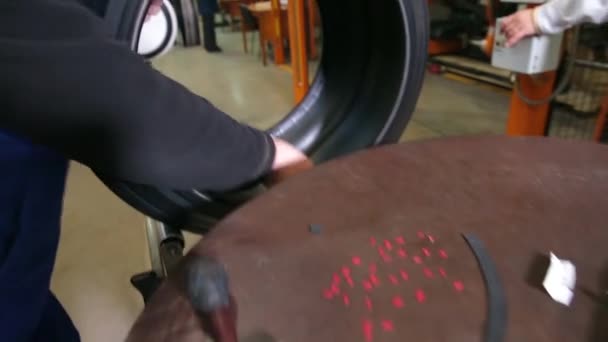 Travailleur prépare pneu pour la prochaine phase de production 