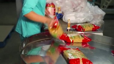 İşçi plastik bir kap içinde noodle torbaları istifleme