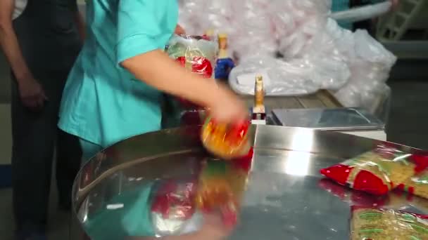 Worker stacking noodle bags in a plastic container — Stock Video