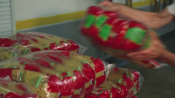 Arbeiter stapelt Nudeltüten in einem Plastikbehälter — Stockvideo