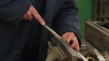 Çilingir bir mengene de büyük bir kısmını dosyalar.