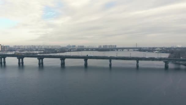 Tráfego em uma ponte sobre um rio largo no inverno . — Vídeo de Stock
