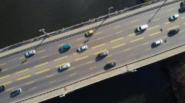Üstteki manzaralı araba, karanlık nehrin üzerindeki köprüde gidiyor..