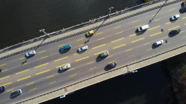 Top view αυτοκίνητο ιππασία σε γέφυρα αυτοκινήτου πάνω από το σκοτεινό ποτάμι. — Αρχείο Βίντεο