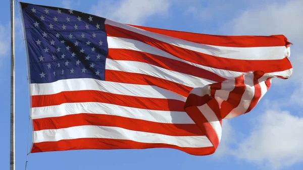 Rüzgarda dalgalanan bir bayrak direğinde Amerikan bayrağı. Amerika Birleşik Devletleri bayrağını dalgalandırıyor. Amerikan bayrağının dalgalanmasını kapat.
