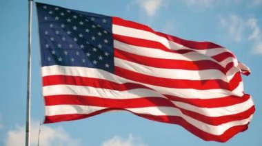 Amerikan bayrağı bulutlarla gökyüzünde dalgalanıyor, ABD.