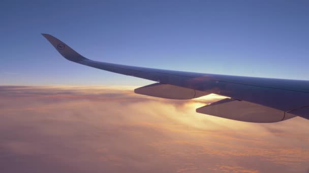 Vol en avion au-dessus des nuages, aperçu du soleil au-dessus de l'aile — Video