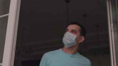 Erkek derin derin nefes alır ve gülümseyerek sokağa bakar.