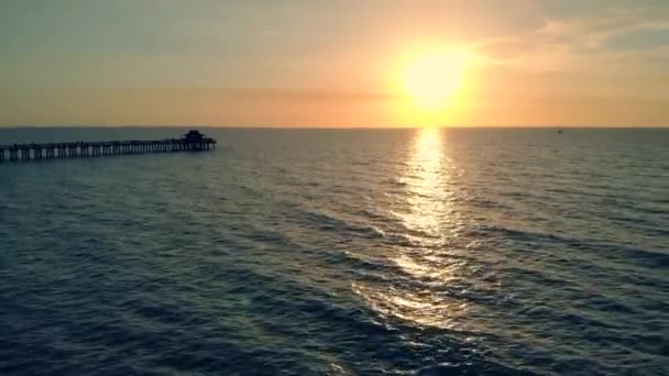 Silhouette d'une jetée au-dessus de l'eau au coucher du soleil, 4k — Video