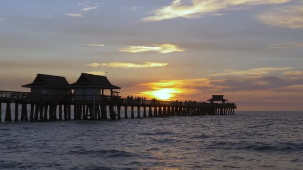 Hermosa puesta de sol sobre el océano, con silueta de muelle — Vídeos de Stock