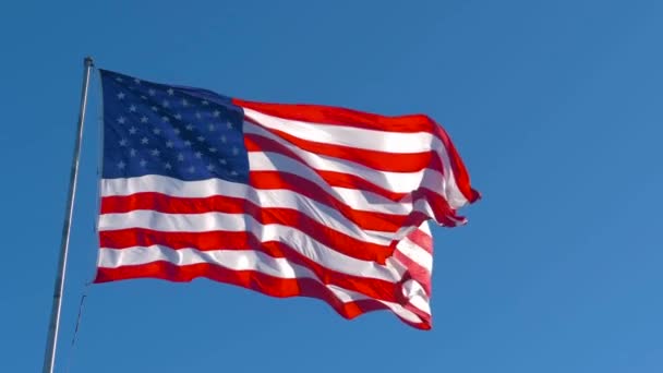 Amerikaanse vlag wapperend in de wind op zonnige dag — Stockvideo