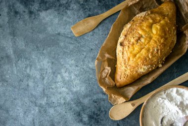 Güzel mısır ekmeği ile peynir kabuk parşömen kağıt üzerine koyu arka plan üzerinde senin yazıt için bir yer var.