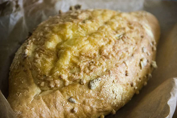 Güzel mısır ekmeği ile peynir kabuk parşömen kağıt üzerine koyu arka plan üzerinde senin yazıt için bir yer var.