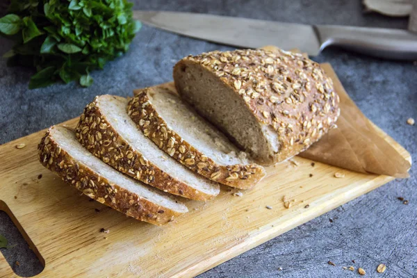 Taş bir tabloda bir gemide tam tahıllı ekmek dilimlenmiş