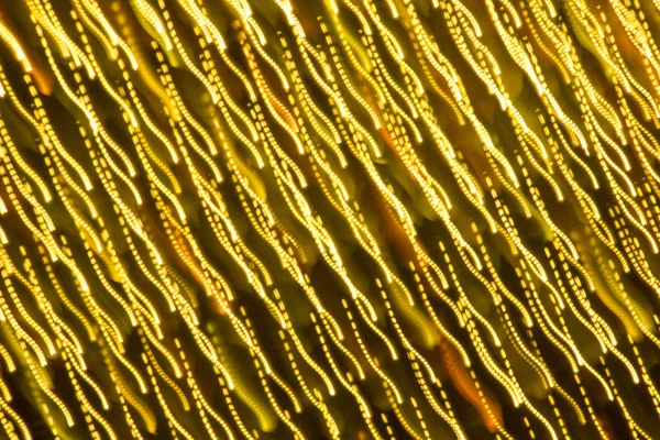 Abstract xmas Gold sparkles or glitter lights. Christmas festive gold background. Defocused bokeh particles. Template for design