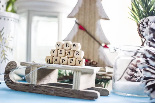 Noel arka plan - ahşap kızak, ağaç, koniler, oyuncak ve beyaz küpleri siyah harflerle 