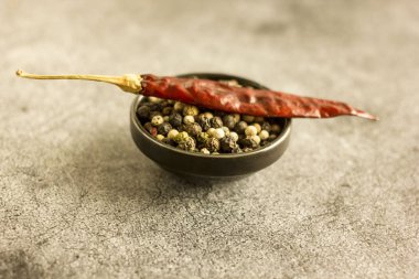  Bir beton zemin üzerine kırmızı, siyah ve beyaz biber karışımı