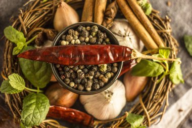 Biber biber, sarımsak, tarçın, soğan ve diğer baharatlar arka planı siyah kase yakın kırmızı, siyah ve beyaz biber karışımı