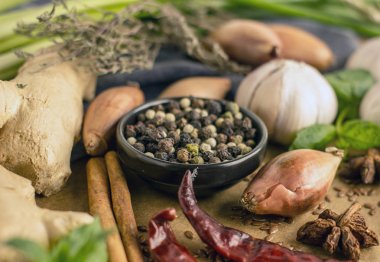 Biber biber, sarımsak, tarçın, soğan ve diğer baharatlar arka planı siyah kase yakın kırmızı, siyah ve beyaz biber karışımı