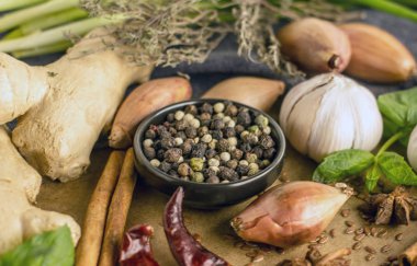 Biber biber, sarımsak, tarçın, soğan ve diğer baharatlar arka planı siyah kase yakın kırmızı, siyah ve beyaz biber karışımı