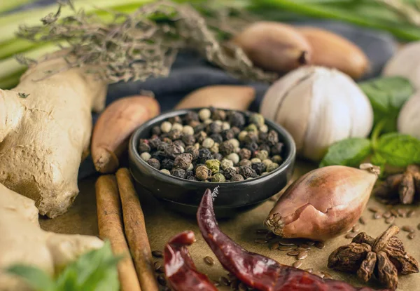 Biber biber, sarımsak, tarçın, soğan ve diğer baharatlar arka planı siyah kase yakın kırmızı, siyah ve beyaz biber karışımı