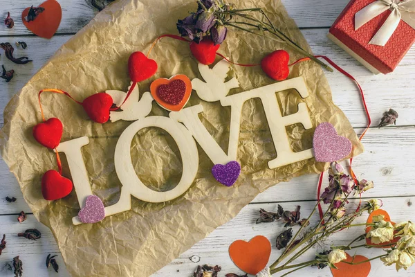 Valentine\'s day background - inscription love made of plywood, hearts, valentines, boxes with a gift