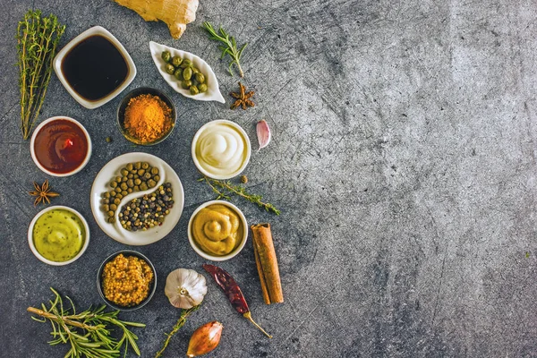 Soslar karanlık bir taş zemin üzerine kümesi. Mayonez, ketçap, soya sosu, hardal, peynir sos, baharat. Yukarıdan görüntülemek