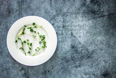 Microgreen karanlık bir arka plan üzerinde beyaz bir tabakta. Kilo kaybı, diyet, bezelye için arka plan beyaz bir tabağa lahanası