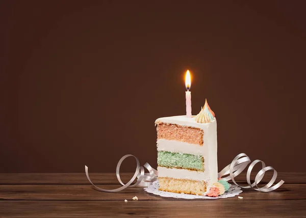 Шматочок торта на день народження зі свічкою — стокове фото