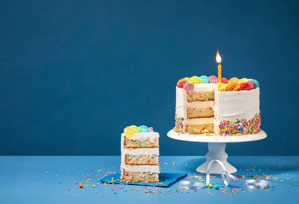 Kolorowy tort urodzinowy z plasterkiem i posypkami — Zdjęcie stockowe