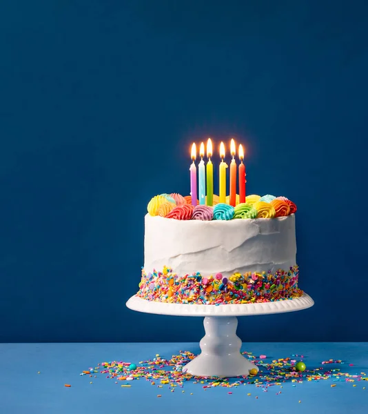 Torta di compleanno variopinta sopra blu — Foto Stock