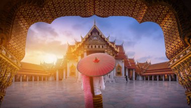 Mermer Tapınak, Bangkok, Tayland, gündoğumu Wat Benchamabopitr Dusitvanaram üzerinde geleneksel kırmızı şemsiye tutan kadın.