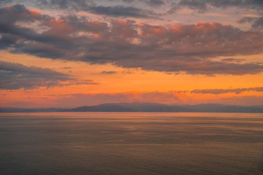 Dramatik gökyüzü arka plan üzerinde deniz ile renkli günbatımı.