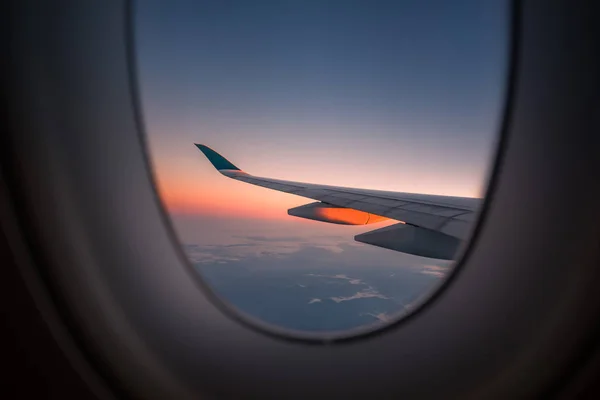 窓からの日の出時に飛行機のシルエットの翼 — ストック写真