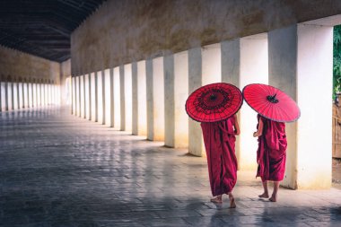 Kırmızı şemsiye tutan ve pagoda, Myanmar yürüyen iki Budist keşiş acemi.
