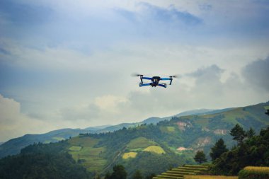 Modern dron Mu Cang Chai, Yenbai, Vietnam, gün batımında teraslı pirinç tarlaları üzerinde uçan kamera ile.