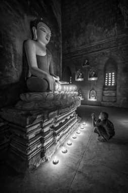 Bagan, Myanmar, 09 Aralık 2017: 09 Aralık 2017 Manastırı Bagan, Myanmar (Burma) içinde dua genç Budist acemi rahip. Siyah ve beyaz sesi