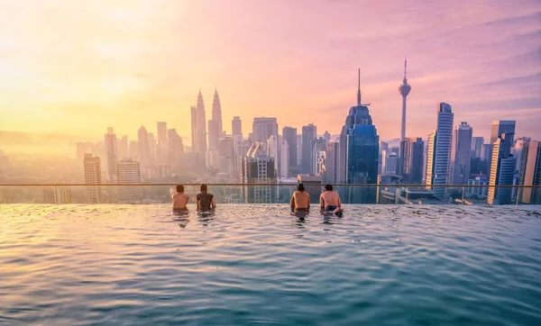 Traveler looking view skyline Kuala Lumpur città in piscina sul tetto dell'hotel all'alba a Kuala Lumpur, Malesia . — Foto Stock