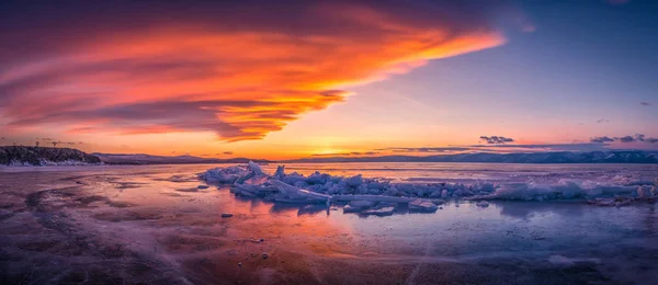 バイカル湖、シベリア、ロシアの凍った水の上に自然の破壊氷と日没の空. — ストック写真