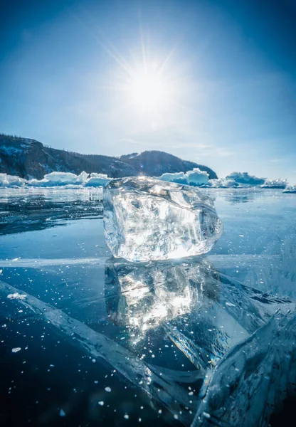 Primer plano de la ruptura natural del hielo con la luz solar en el agua congelada en el lago Baikal, Siberia, Rusia . — Foto de Stock