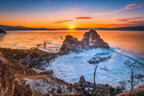Paisaje de la roca de Shamanka al atardecer con hielo natural en agua helada en el lago Baikal, Siberia, Rusia . — Foto de Stock