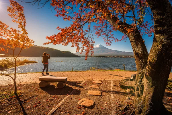 Mt. Fuji át Kawaguchiko-tó partjától őszi lombozat és utazó nő napkeltekor, Fujikawaguchiko, Japán. — Stock Fotó